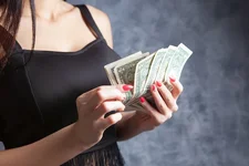 depositphotos_495097746-stock-photo-young-woman-counting-money-gray.jpg.webp